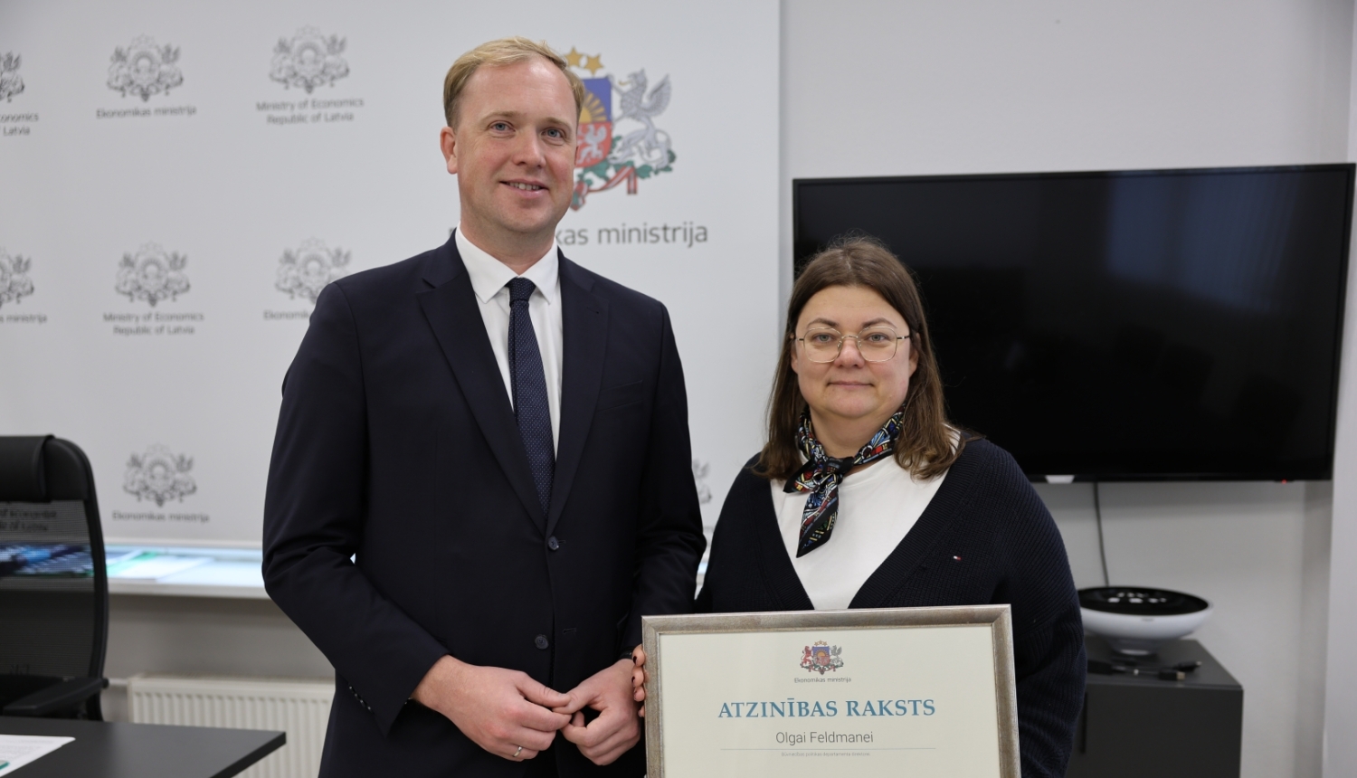 Viktors Valainis Pasniedz pateicības rakstu O.Feldmanei