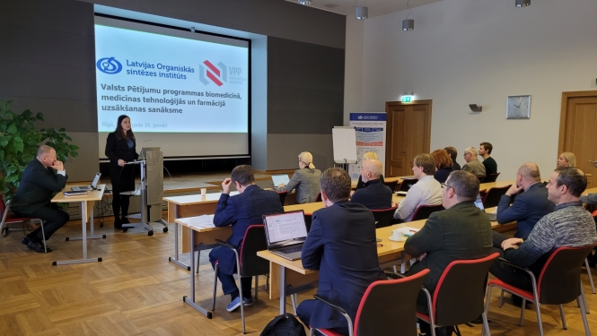 Sieviete prezentē, auditorija skatās prezentāciju