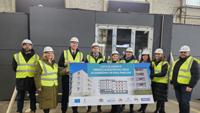 Ekonomikas ministrs un citi iesaistītie tur informatīvu plakātu par koka paneļu ražošanas uzsākšanu