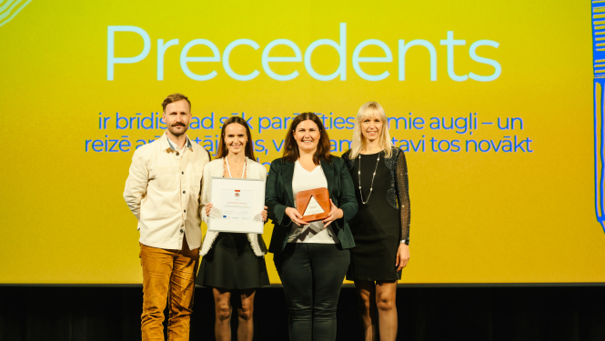 Ekonomikas ministrijas un Valsts kancelejas pārstāvji ar atzinību rokās