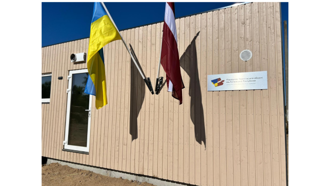 Moduļu mājas siena ar Ukrainas un Latvijas karogiem