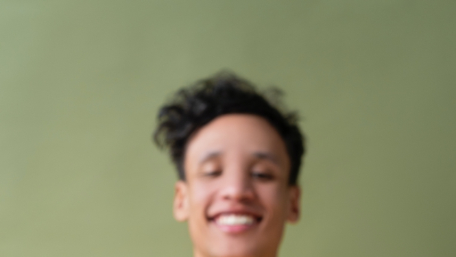 Jauns vīrietis dzeltenā kreklā ar spuldzi rokas