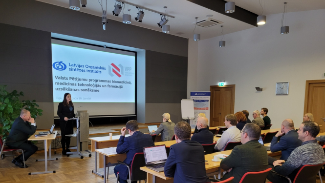 Sieviete prezentē, auditorija skatās prezentāciju