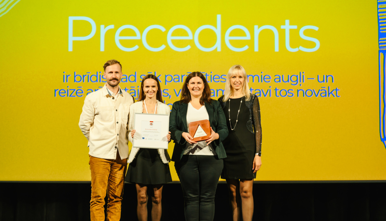 Ekonomikas ministrijas un Valsts kancelejas pārstāvji ar atzinību rokās